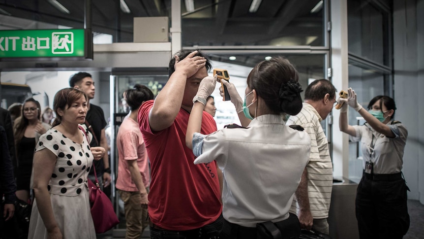 Passengers in Hong Kong have their temperature checked