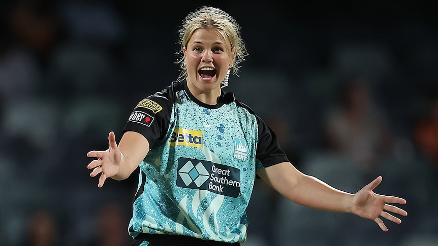 Brisbane Heat bowler Georgia outstretches her arms and shouts with joy after a Perth Scorchers WBBL wicket.