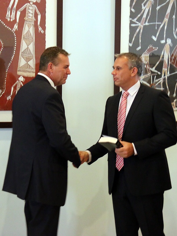 NT Treasurer Dave Tollner (left) shakes the hand of Chief Minister Adam Giles.