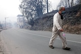 A man leaves a village near Algiers wildfires in this mountainous region. 