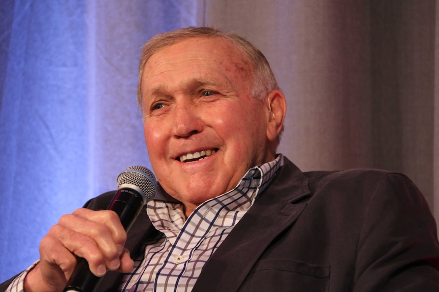 Bob Skilton speaks while holding a microphone at an event in Melbourne.