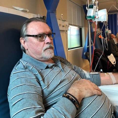 Les Morris sitting in a chair receiving chemotherapy