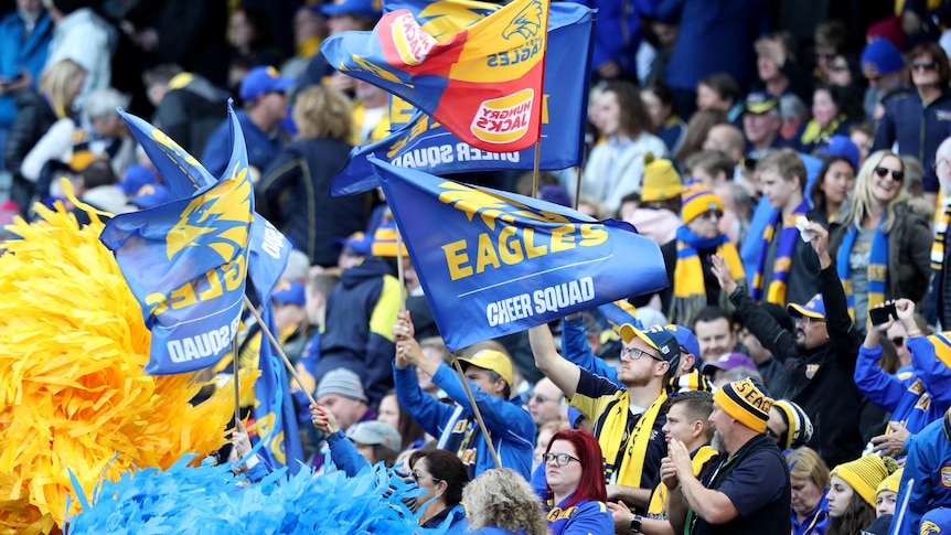 West Coast Eagles fans wave banners and clap during a Western Derby against Fremantle Dockers