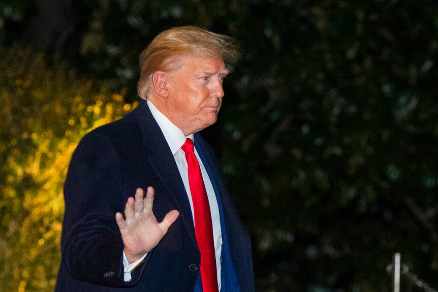 President Donald Trump waves as he leaves the White House.