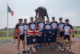 Group of men in cycling gear holding Australian flag