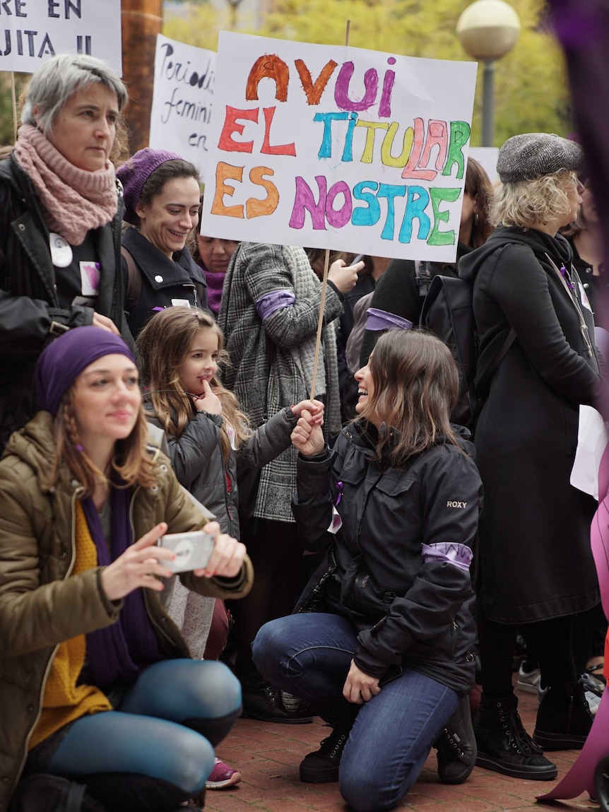 A woman holds a placard saying "today we are the headline".