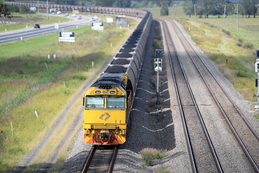 train carriages filled with black rocks in a rail line