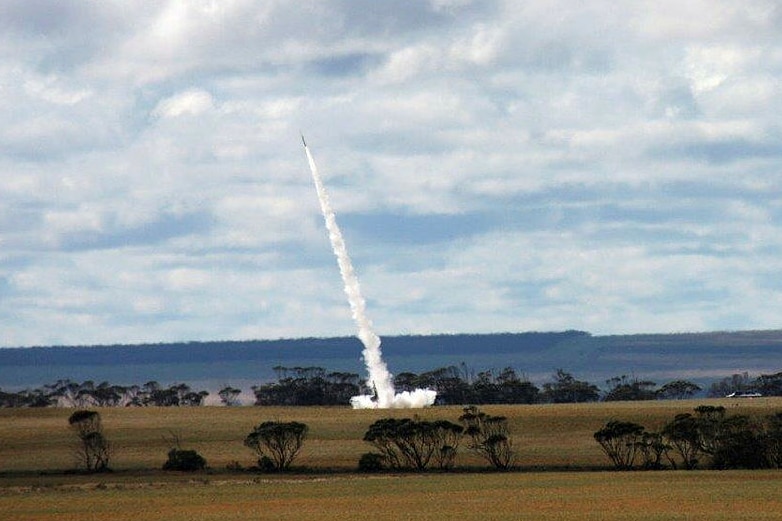 A rocket flies over farmland