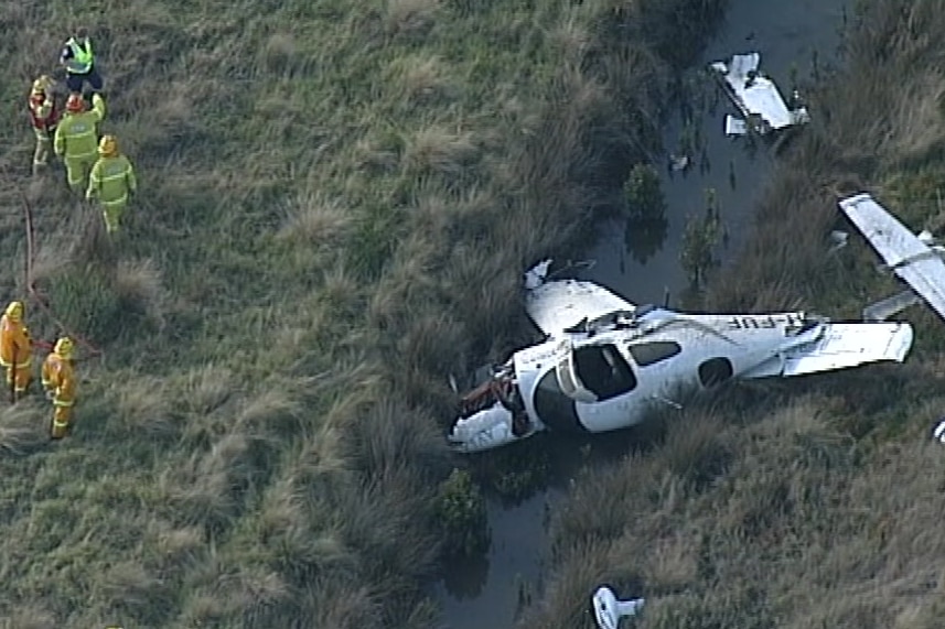 An aerial image of a crashed light plane in a grassy ditch.