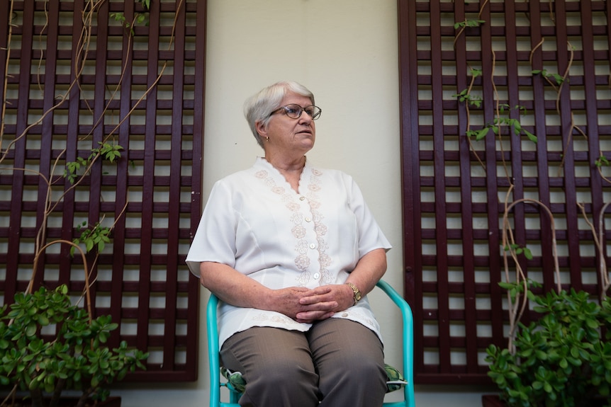 Woman sits on chair outside