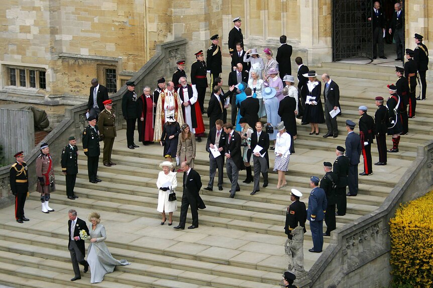 Britain's Prince Charles and the Duchess of Cornwall walk from St George's Chapel and followed by a crowd.
