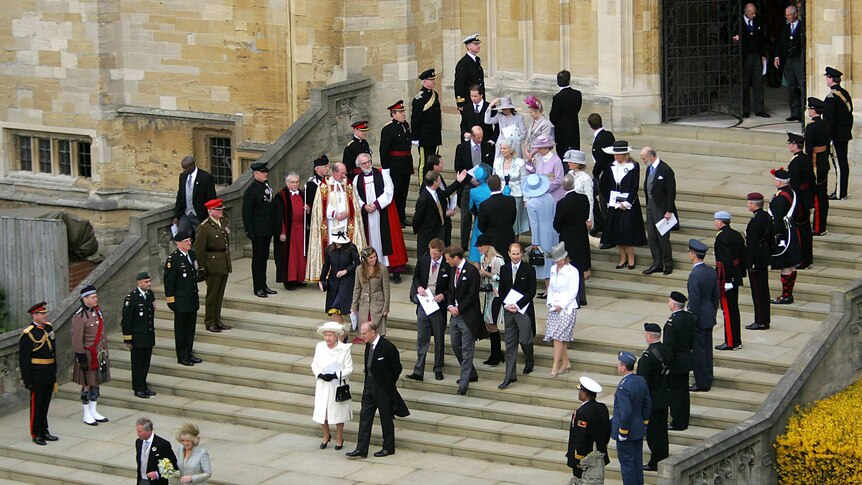 Britain's Prince Charles and the Duchess of Cornwall walk from St George's Chapel and followed by a crowd.