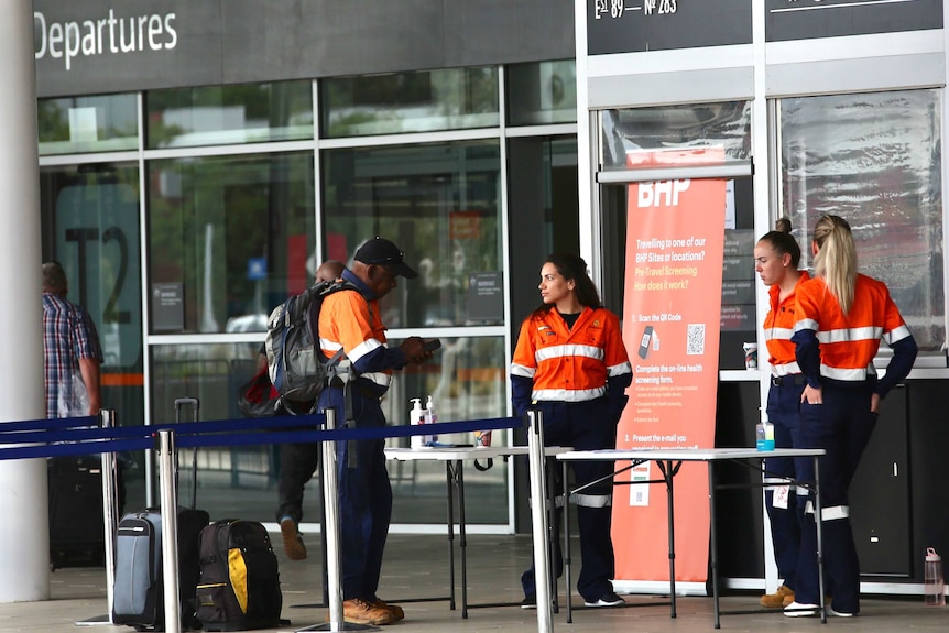A B-H-P fly in fly out worker queues to be screened for COVID-19 outside Perth Airport's Terminal 2.