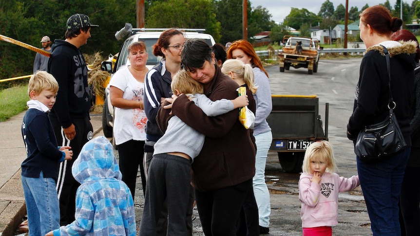 A resident is consoled after losing her house in Dungog