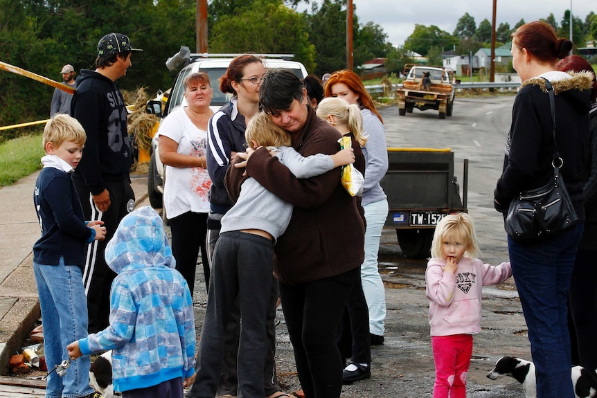 A resident is consoled after losing her house in Dungog