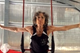 Older woman on a trapeze in a cruciform position