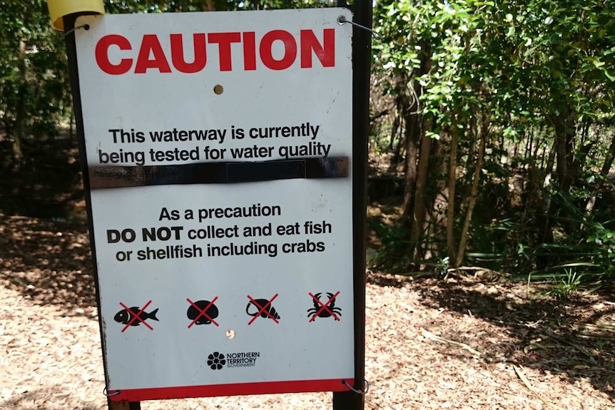 A sign warning people not to collect or eat fish or shellfish as the water quality is being tested
