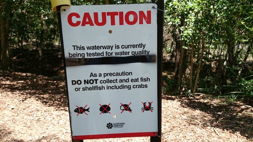 A sign warning people not to collect or eat fish or shellfish as the water quality is being tested