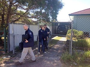 Australian Federal Police officers leave a house in Logan that was part of anti-terrorism raids