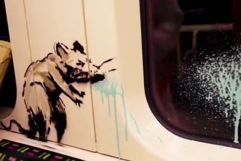 A painting of a ran standing on a train seat, sneezes blue paint onto the glass.