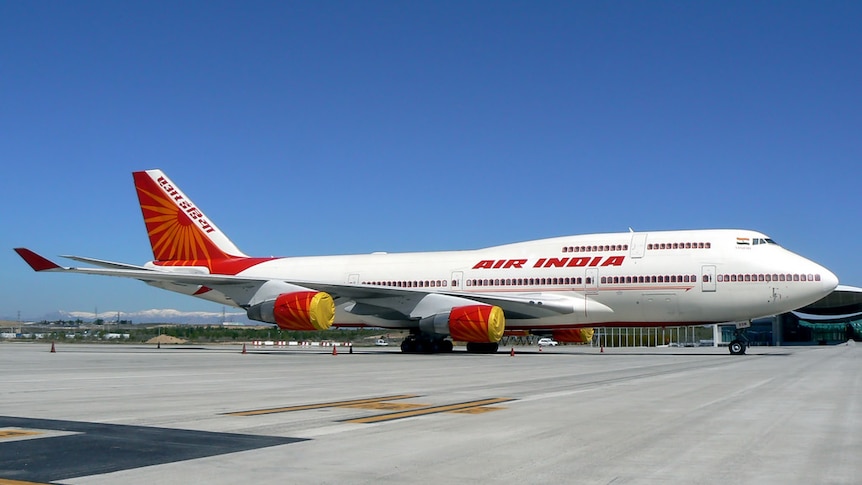 An Air India Boeing 747-400 sits taxis on a runway.