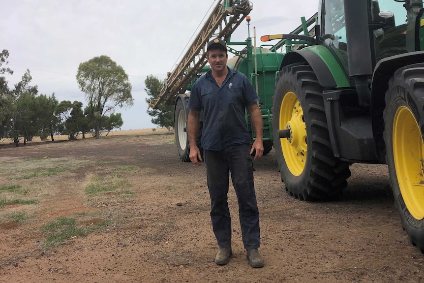 Man standing next to a tractor.