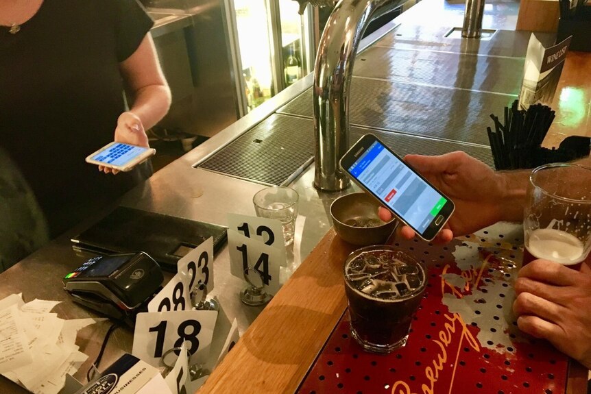 A customer buying beer with bitcoin at a pub
