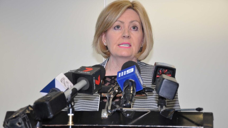 Perth Lord Mayor Lisa Scaffidi speaks at a press conference with a cluster of microphones in front of her.