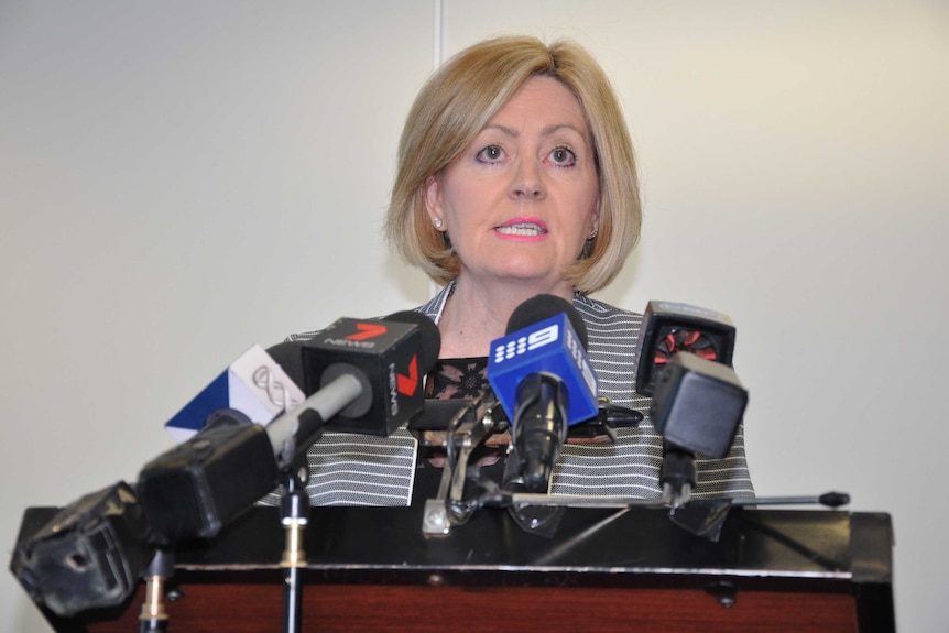 Perth Lord Mayor Lisa Scaffidi speaks at a press conference with a cluster of microphones in front of her.