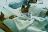 Patients lie in a bed in a Homs military hospital