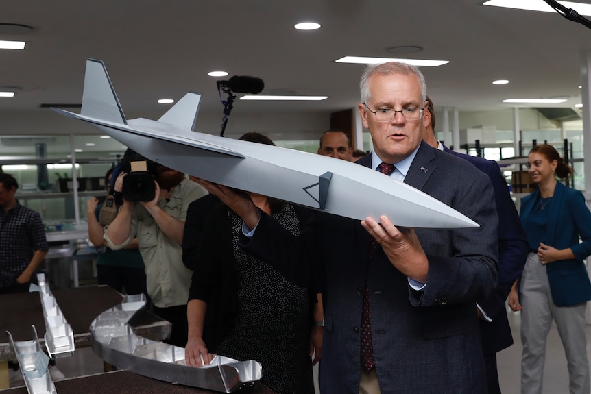 Scott Morrison holds a model plane. 