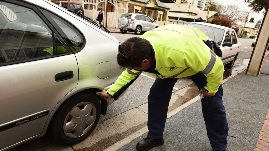 Parking inspector chalks a tyre