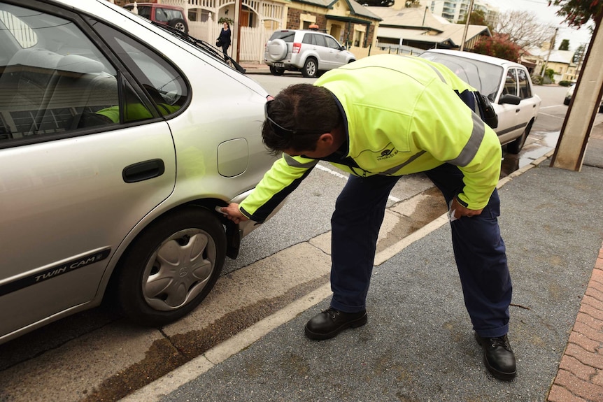 Parking inspector chalks a tyre