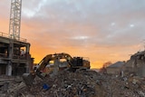 A digger sits on rubble at 10 Murray Street Hobart