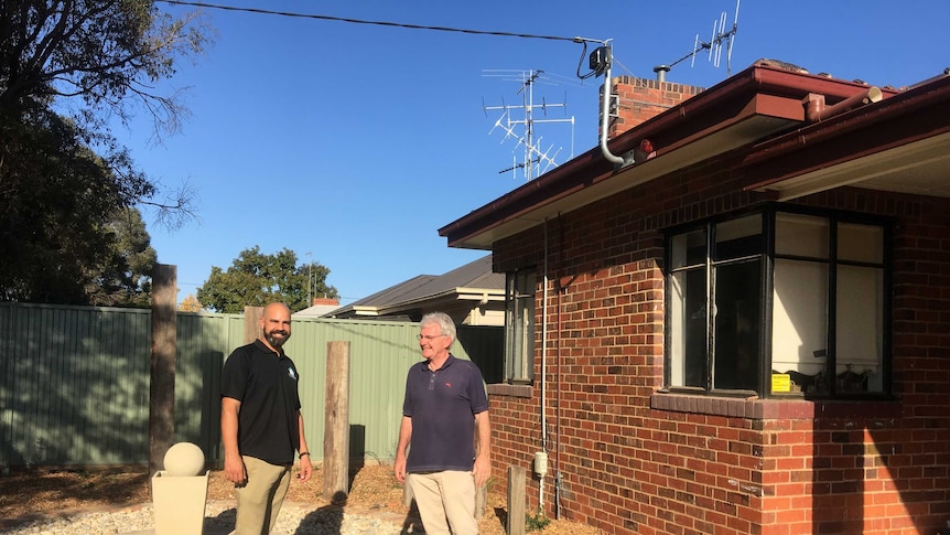 Joshua Simm and Robert Bryant  standing in the garden of the cottage, a community funded residential rehab.