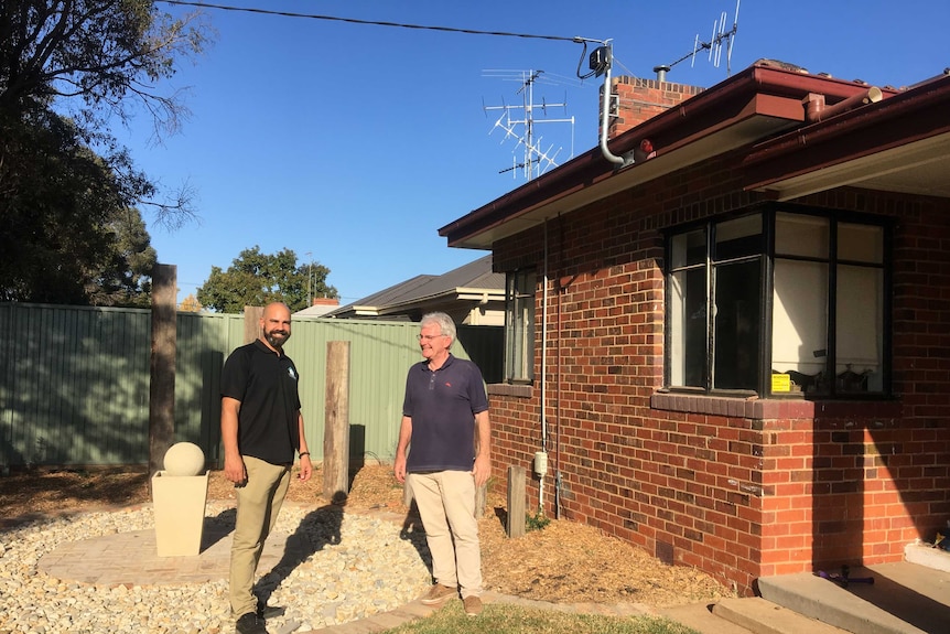 Joshua Simm and Robert Bryant  standing in the garden of the cottage, a community funded residential rehab.