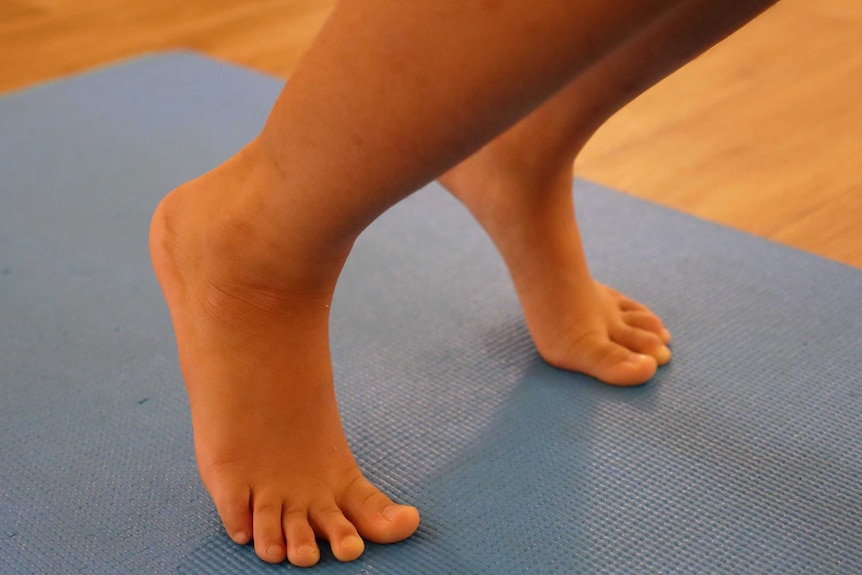 Close up of a child's feet on a yoga mat