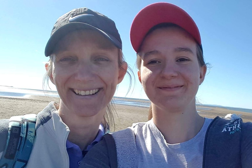 Julie Richards and her daughter Jessica Richards smile in a selfie taken on a beach.