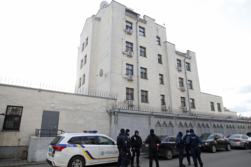 Police officers and members of the Ukrainian National Guard are seen outside the Russian embassy in Kyiv, Ukraine.