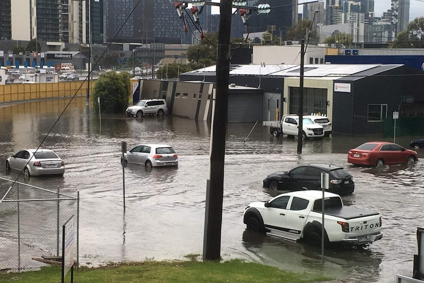 Cars drive through floodwaters in Port Melbourne.