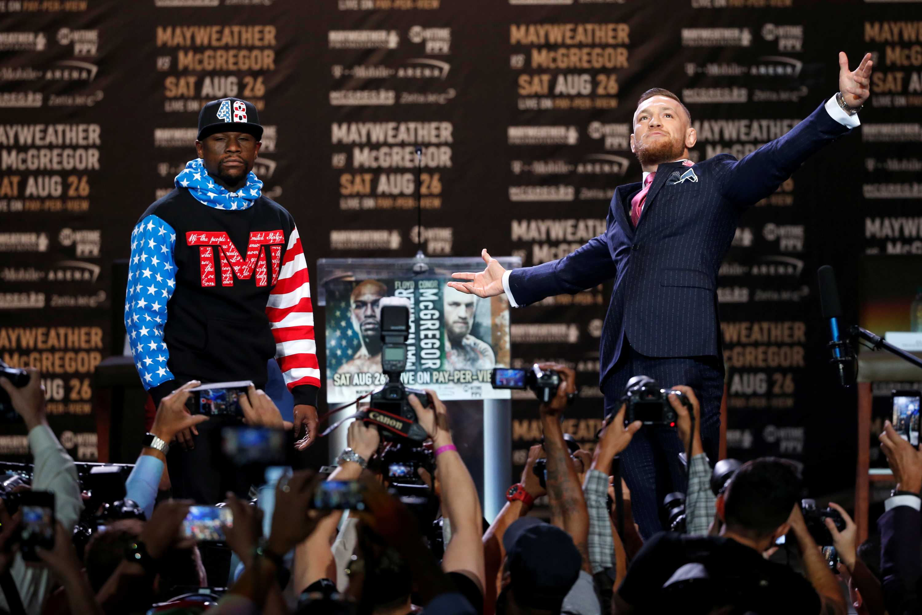 Floyd Mayweather looks ahead while Conor McGregor looks dramatically to the heavens at their press conference.