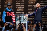 Floyd Mayweather looks ahead while Conor McGregor looks dramatically to the heavens at their press conference.