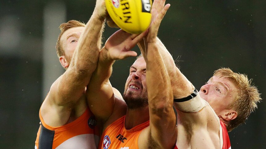 Giant shock ... GWS's Jonathan Giles (L) and Tim Mohr (C) compete with Sydney's Jordan Lockyer.