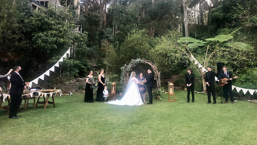A couple gets married in a large garden.
