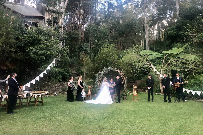 A couple gets married in a large garden.