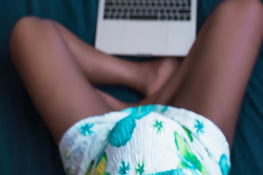 Pregnant woman with a laptop in front of her