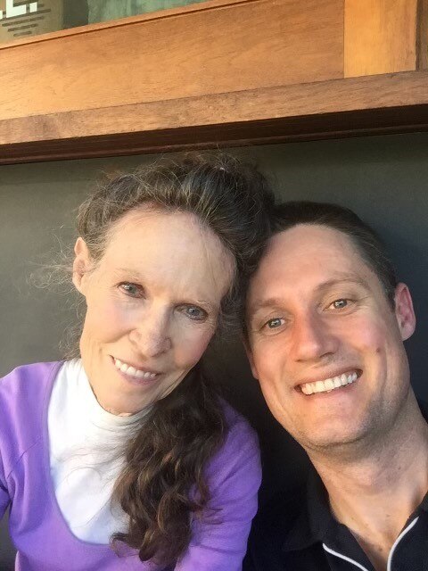 An elderly woman and younger man smiling.