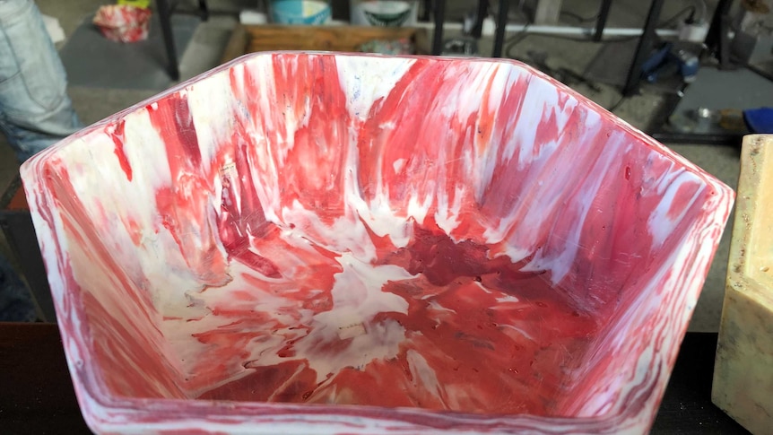 A bowl made from pink and white plastic melted together in a marbled effect.
