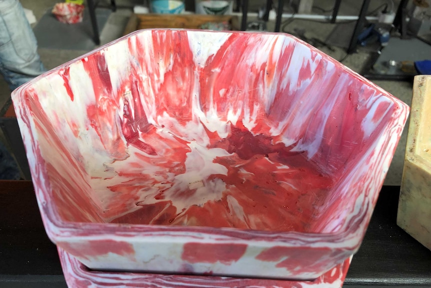 A bowl made from pink and white plastic melted together in a marbled effect.