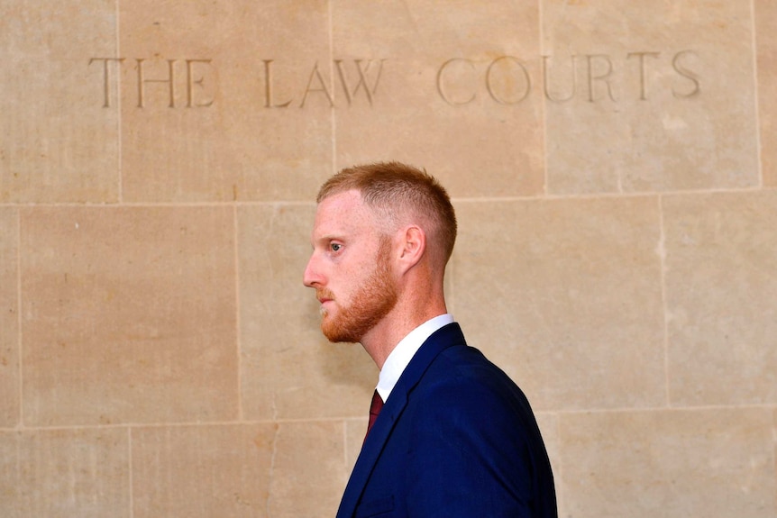 A ginger man under a sign saying The Law Courts.